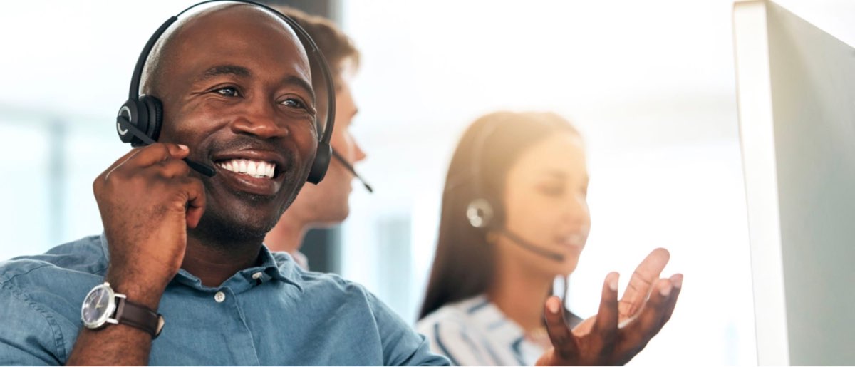 A man assisting someone through a headset over the phone