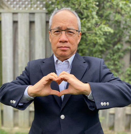 Canon Canada President and CEO Nobu Kitajim making a heart shape with his hands